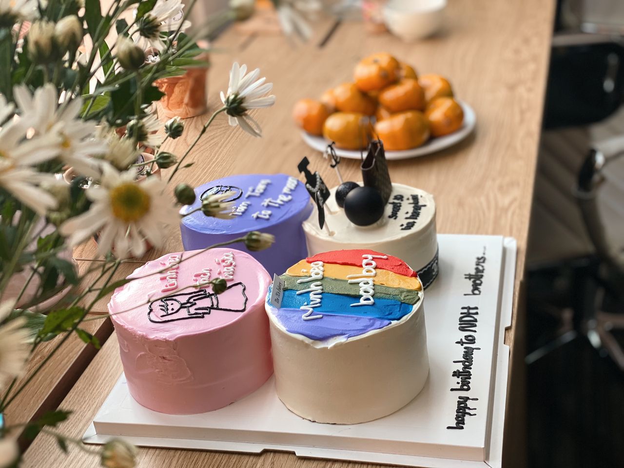 ours-journey Three creatively decorated birthday cakes with colorful themes on a wooden table.