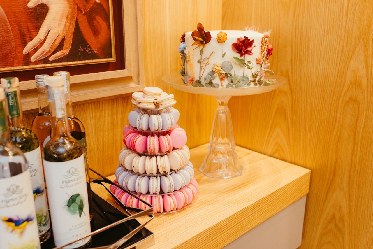 services-01 Vibrant macaron tower and floral cake on wooden table, perfect for celebrations.