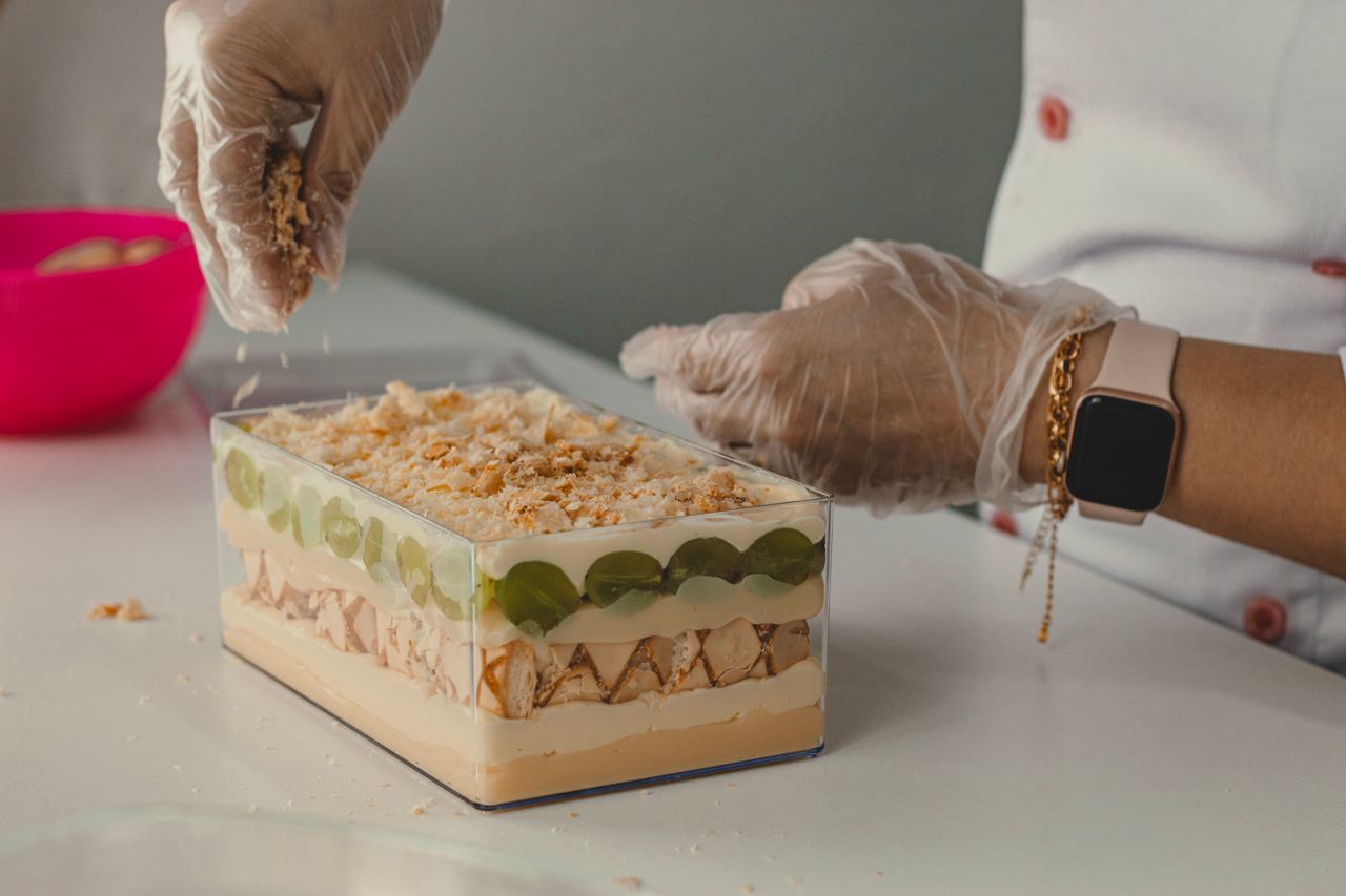 Crafting Captivating Headlines: Your awesome post title goes here A person wearing gloves carefully prepares a layered dessert.